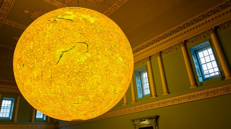 Helios, a brightly lit sculpture of the sun displayed at Bath Assembly Rooms, Somerset